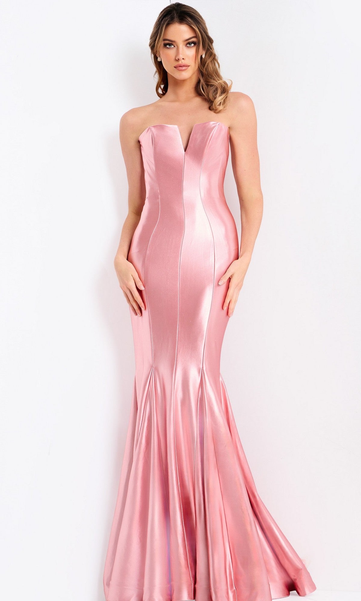 A woman poses against a white background wearing the Jovani 48744 long prom dress in rose/gold, a strapless satin mermaid style with a fitted, shiny silhouette reminiscent of classic prom gowns.